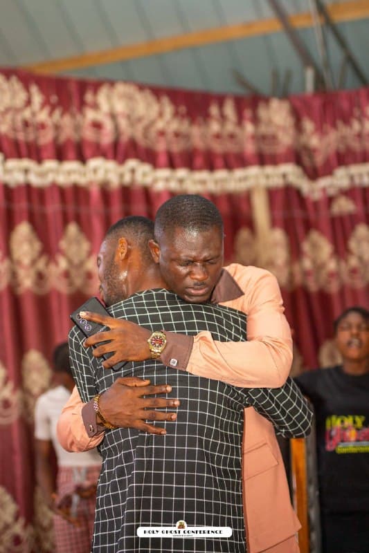 Two ministers embracing in prayer